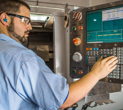 HP Manufacturing employee at the controls of a plastics machining unit at our plant in Cleveland, OH